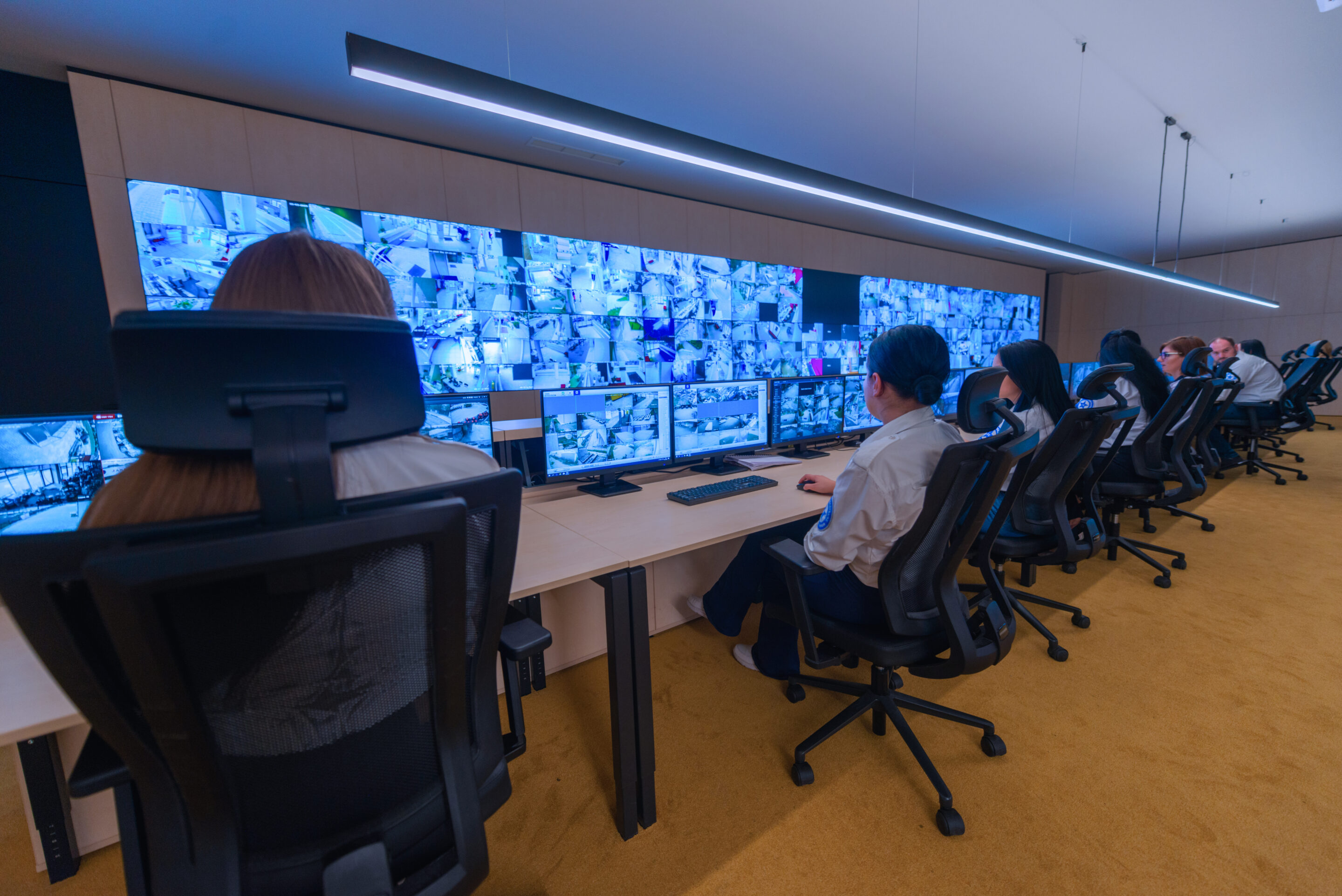 Female security operator working in a security data control room offices