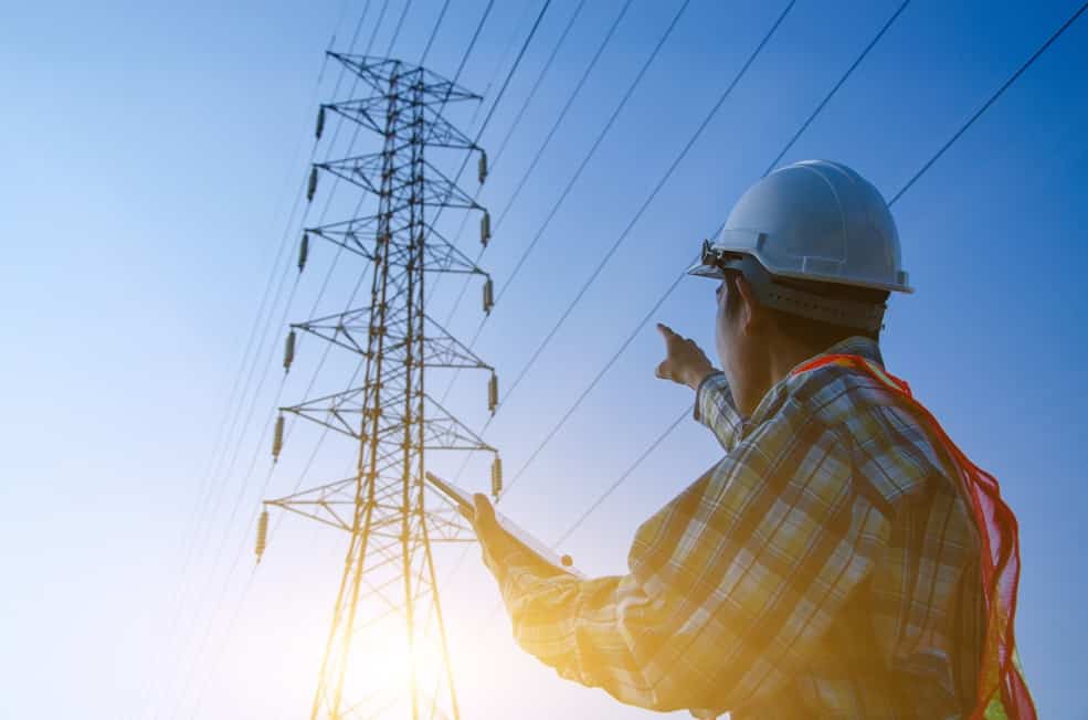 High-voltage power transmission grid at dusk representing utilities and energy infrastructure monitoring